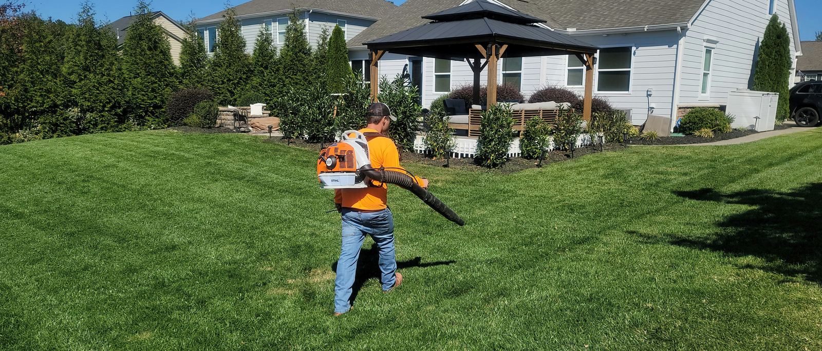 An Arroyo crew member using a backpack blower to clear a freshly mowed lawn
