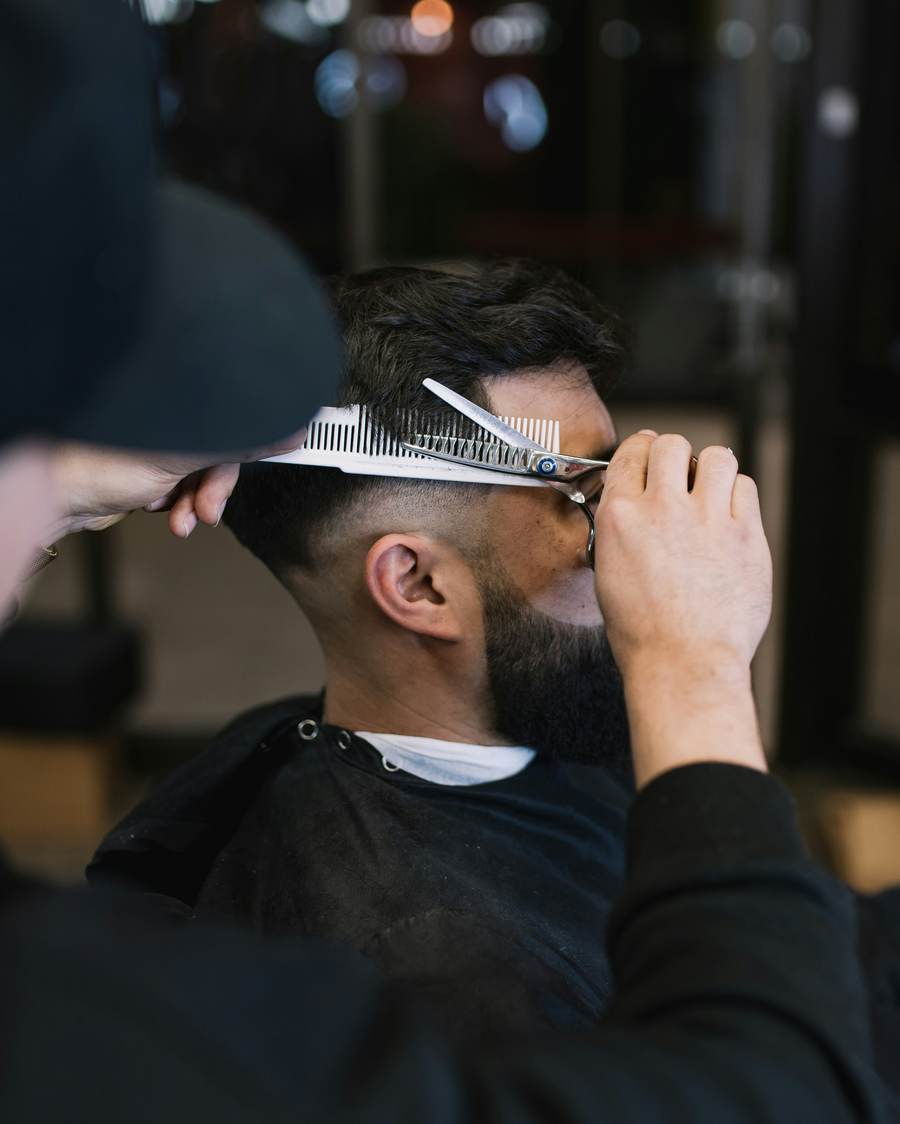 Barber giving a precise scissor cut